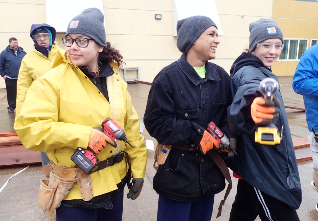 Students holding electric drills