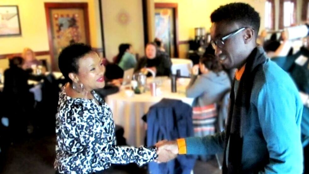 Presenter Robinson shakes the hand of an attendee
