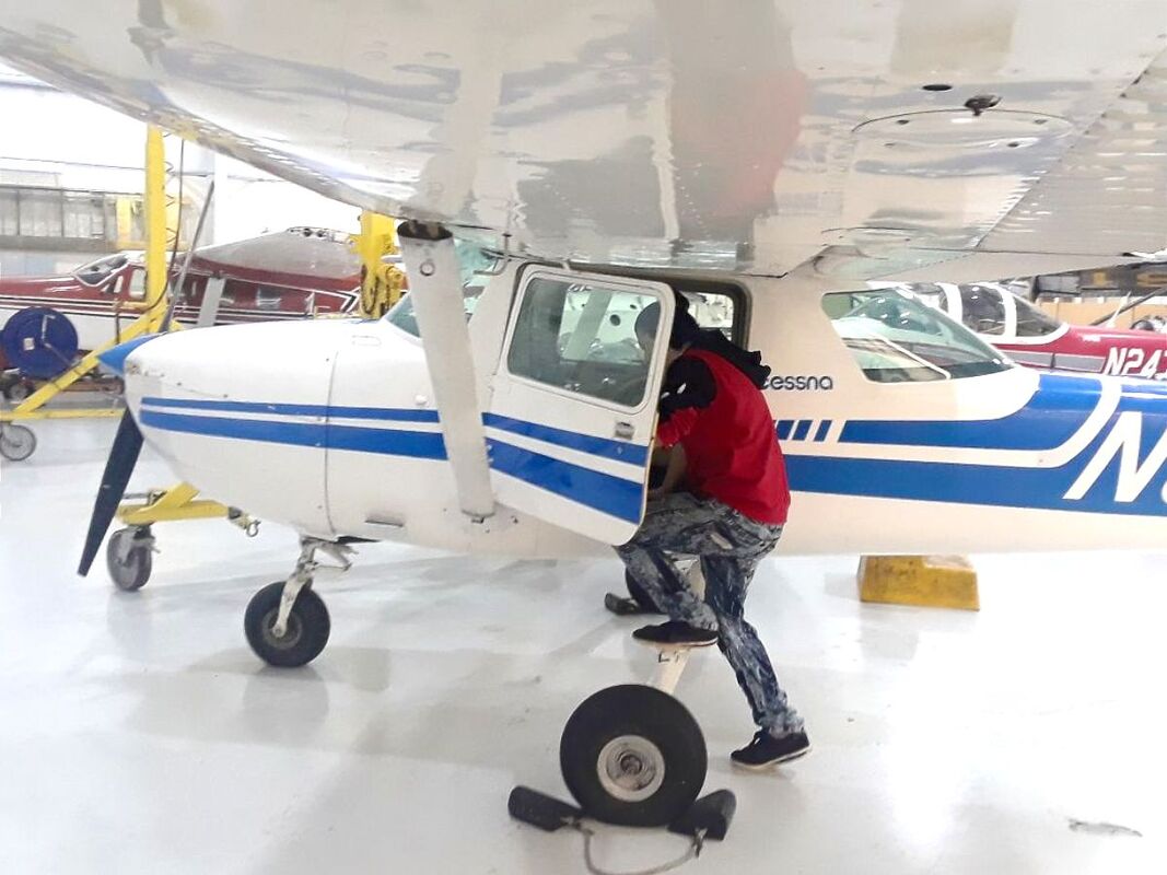student climbing into small aircraft
