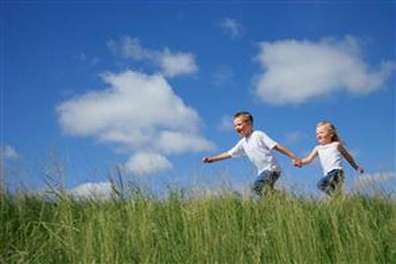 Children running through meadow